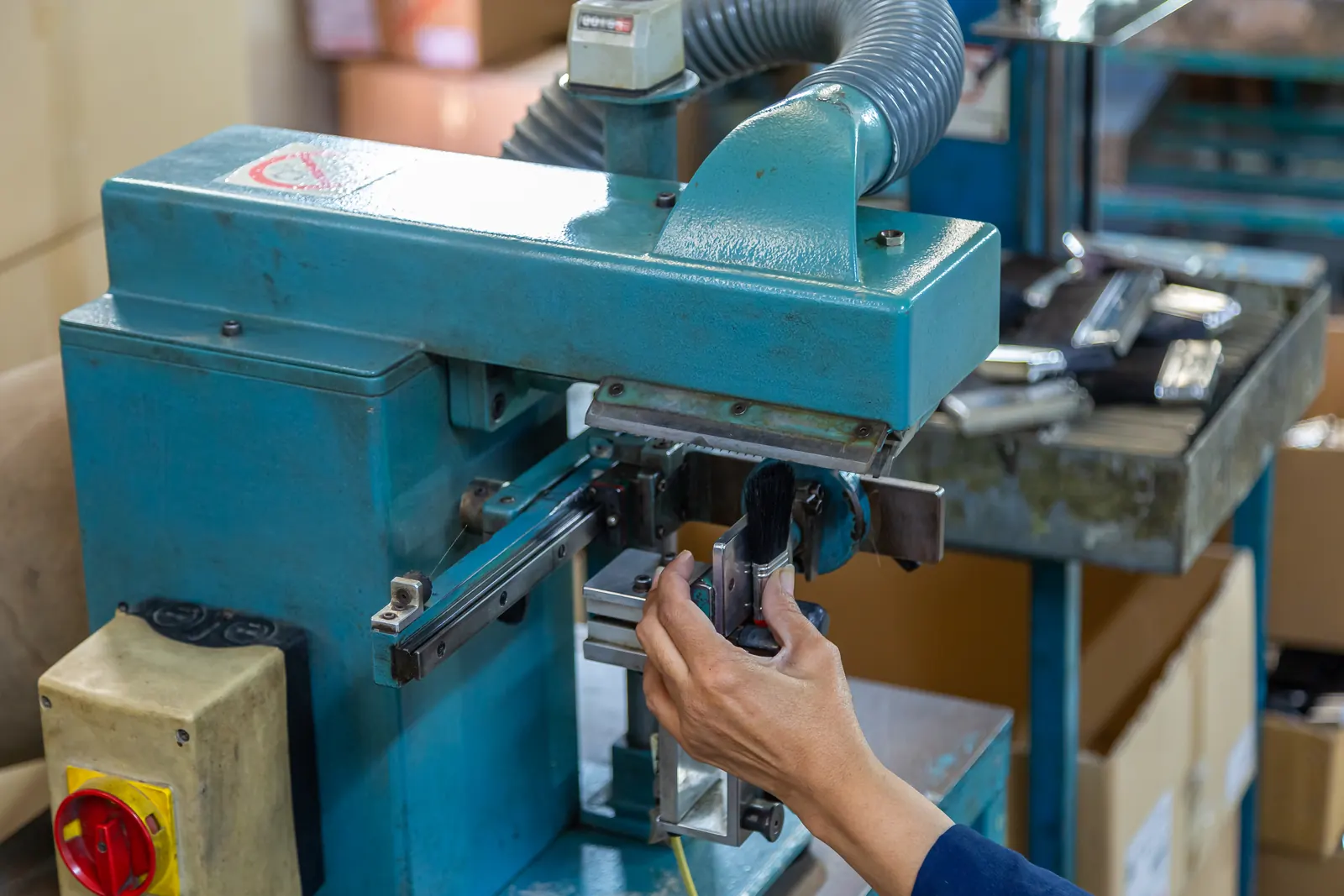Hands guiding a brush through the machine on a PETA production line